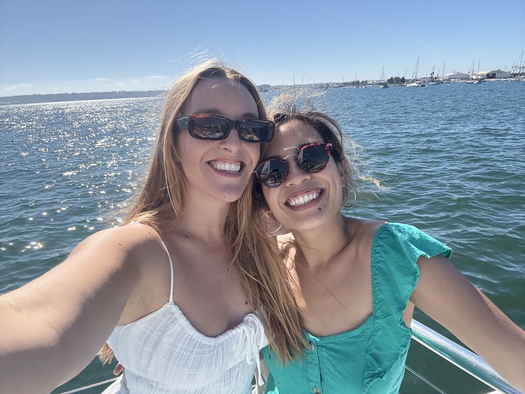 Two friends smiling on a boat on a sunny day