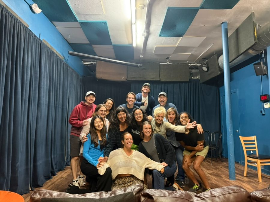 An improv class posing together on stage