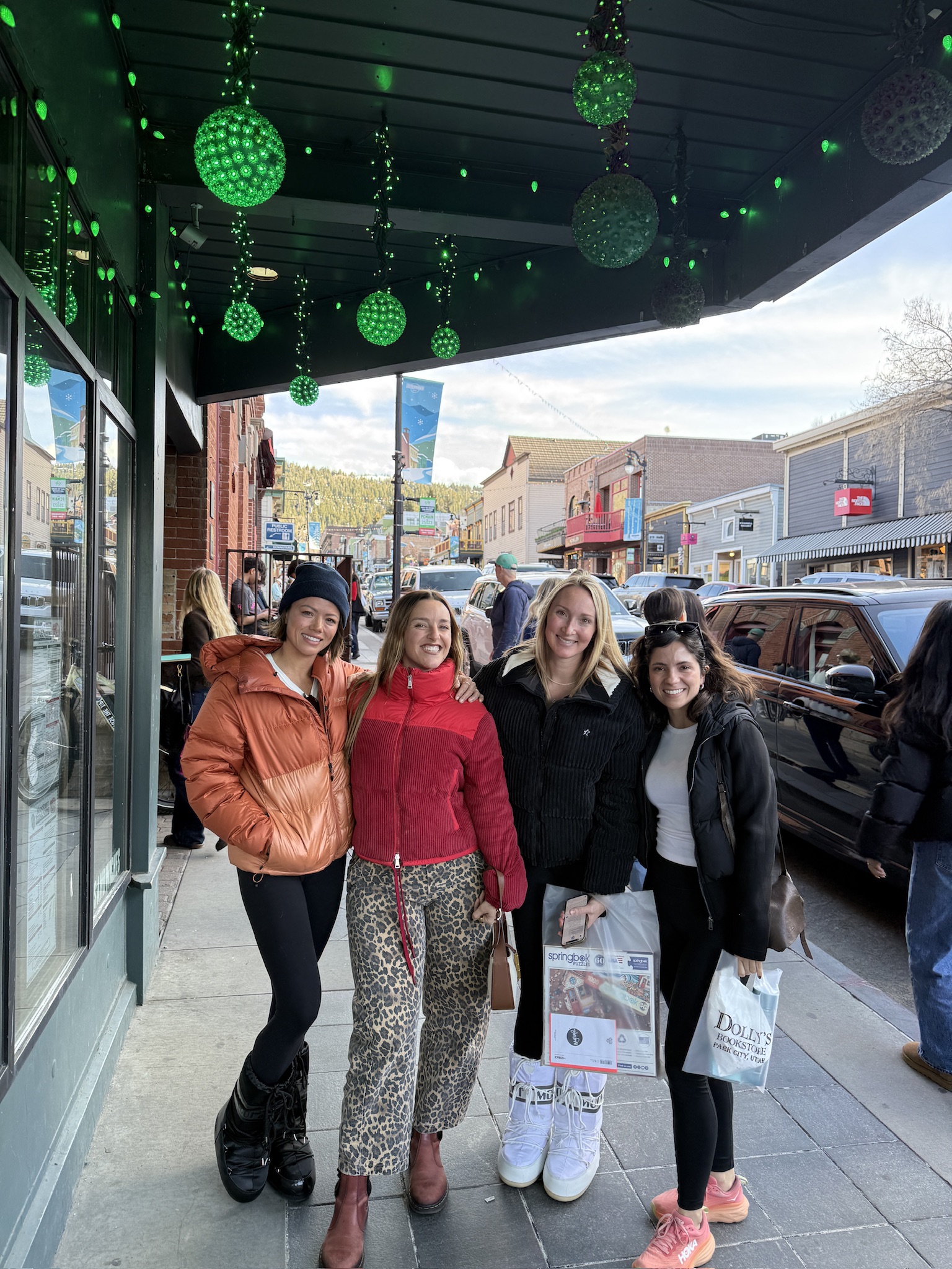 Four friends bundled up together on a snowy main street